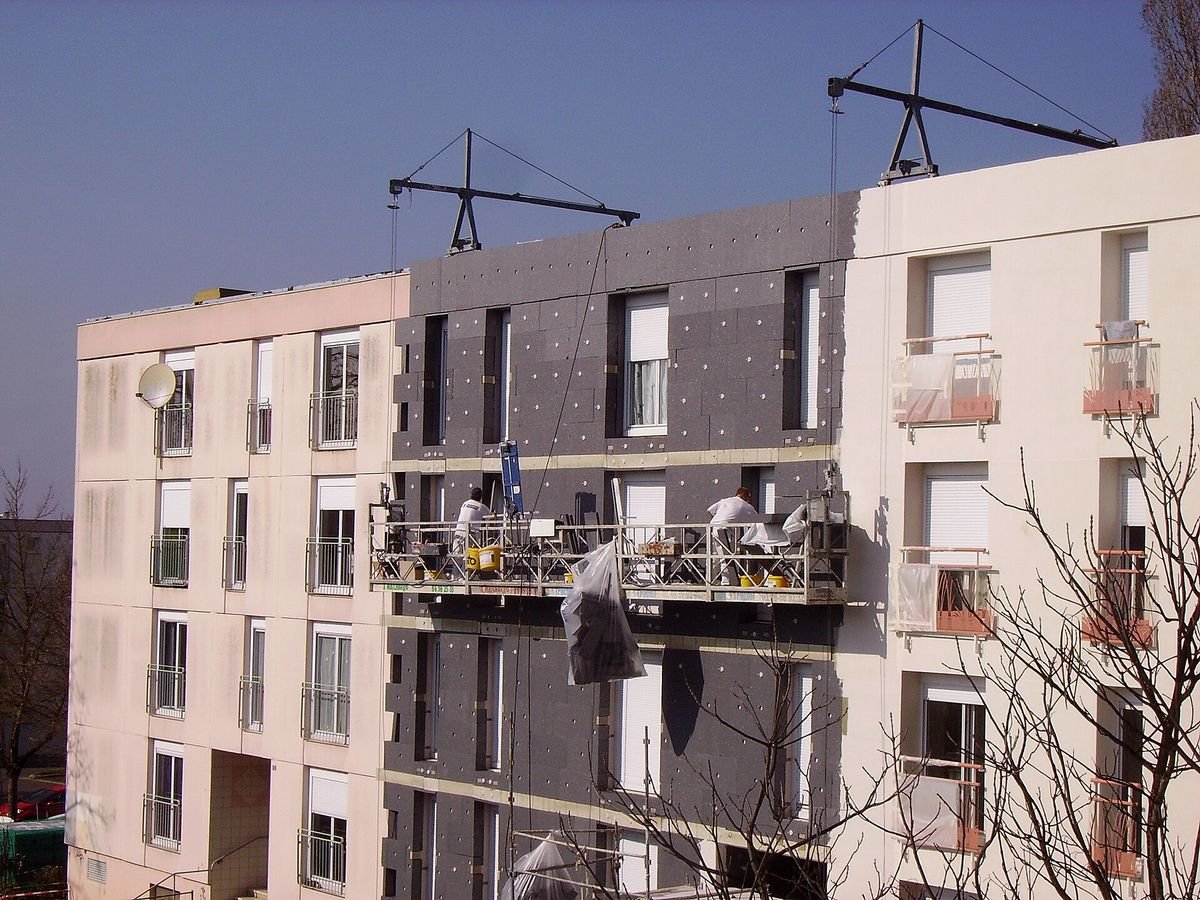 Reinforcement and base coat applied over external wall insulation